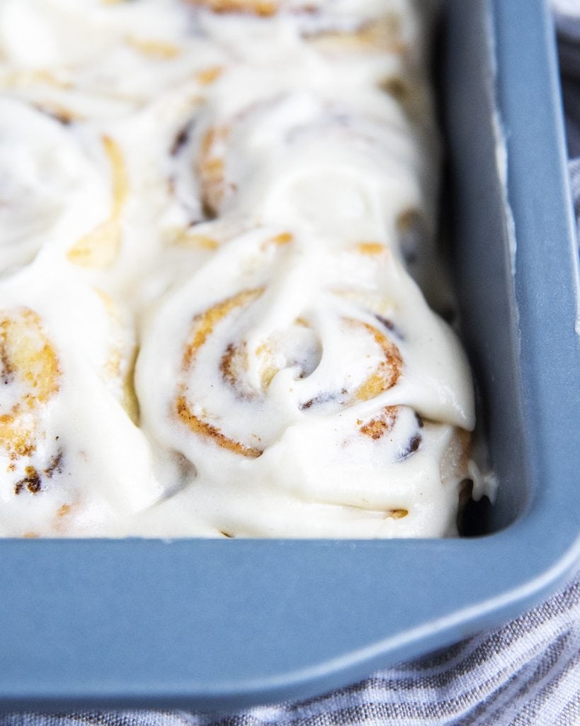No Yeast Cinnamon Rolls topped with frosting in a square baking pan.