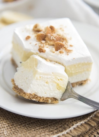 A piece of banana cream pie bar with a portion cut out with a fork.