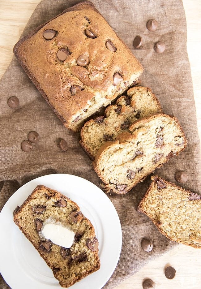 Top view of chocolate chip banana bread on a brown backdrop.