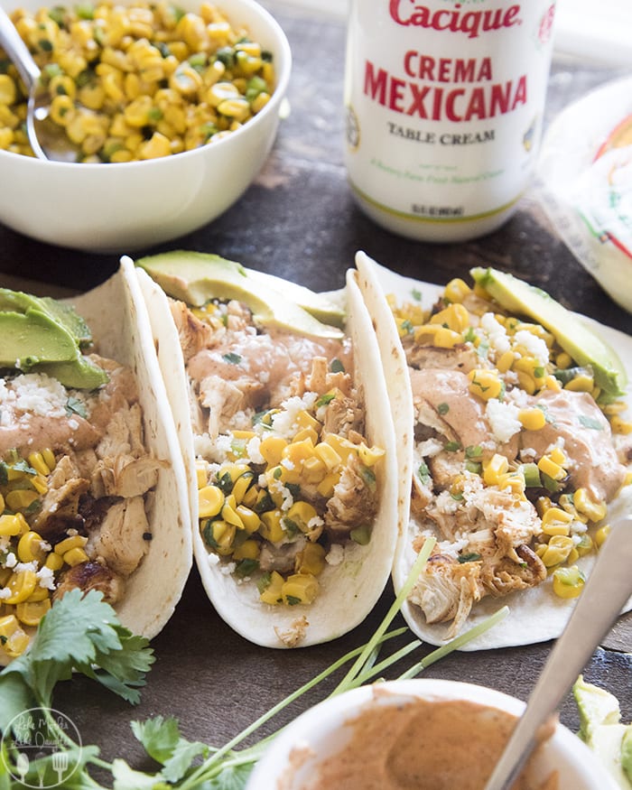 Three Chicken and street corn tacos next to each other.