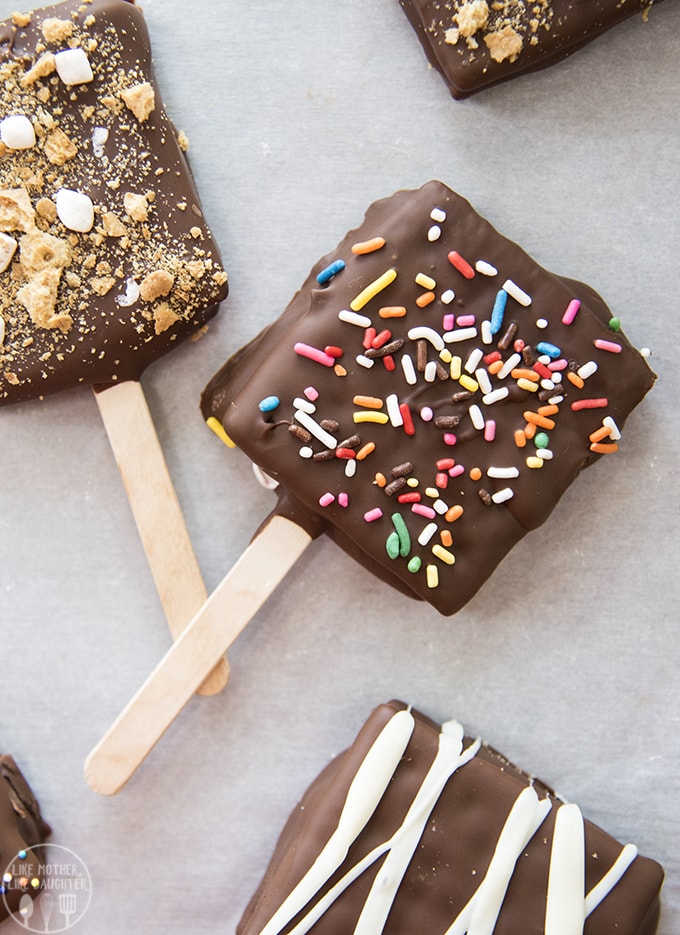 A chocolate covered smores pop topped with rainbow sprinkles. 