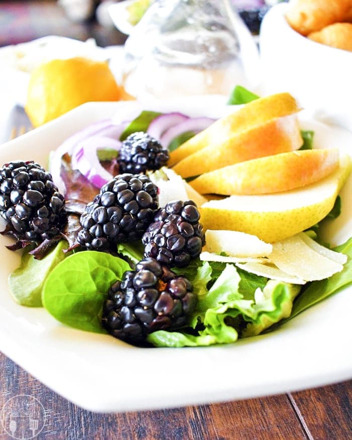A pear and blackberry salad on a plate.