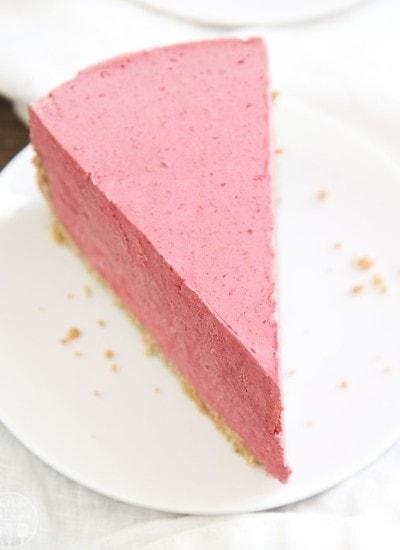 A piece of frozen raspberry pie on a white plate.