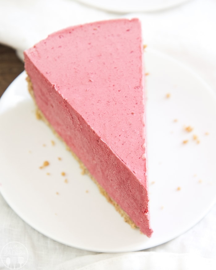 A piece of frozen raspberry pie on a white plate.