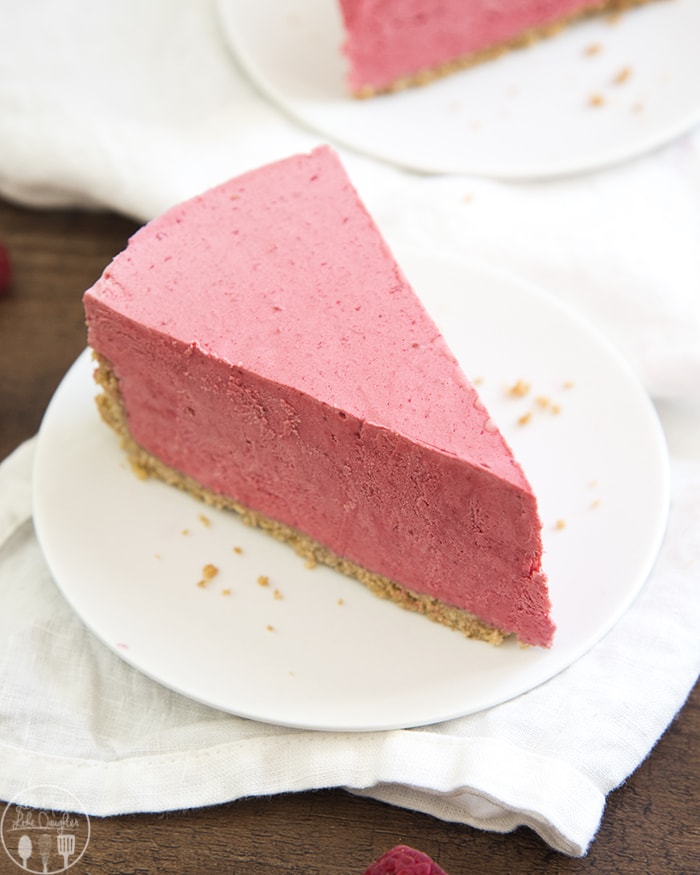 A slice of a pink frozen raspberry pie on a plate. 