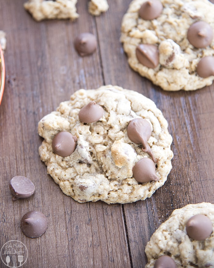 An oatmeal chocolate chip cookie on a wooden board.