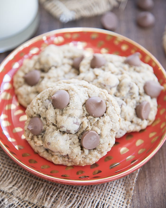A plate topped with three oatmeal chocolate chip cookies.