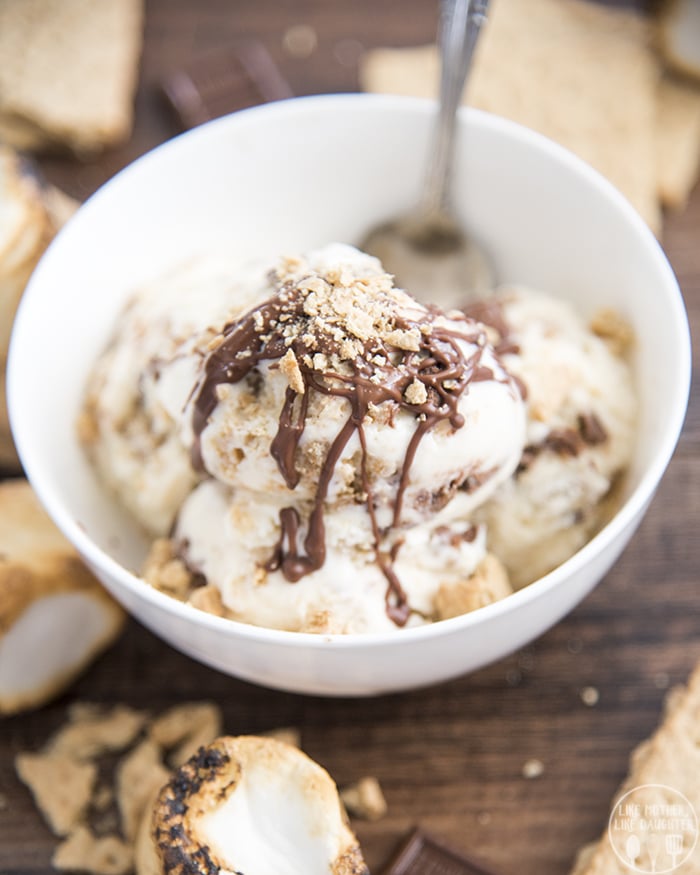 A bowl of smores ice cream topped with drizzled chocolate and graham cracker crumbs.
