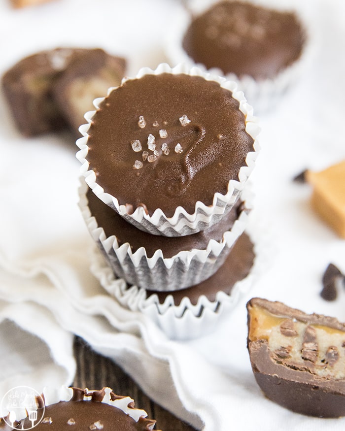 A pile of three chocolate candy cups topped with sea salt. 