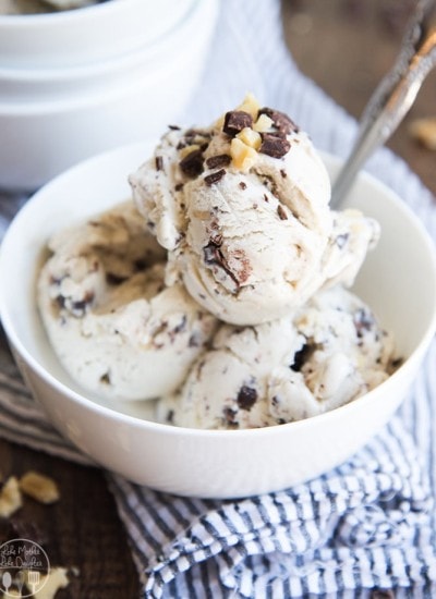A bowl of banana ice cream topped with chocolate chunks and walnuts.