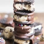 A stack of Oreos stuffed with cookie dough and dipped in melted chocolate.