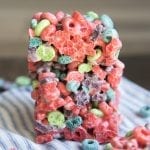 A stack of two fruit loop marshmallow treats on a blue and white cloth.
