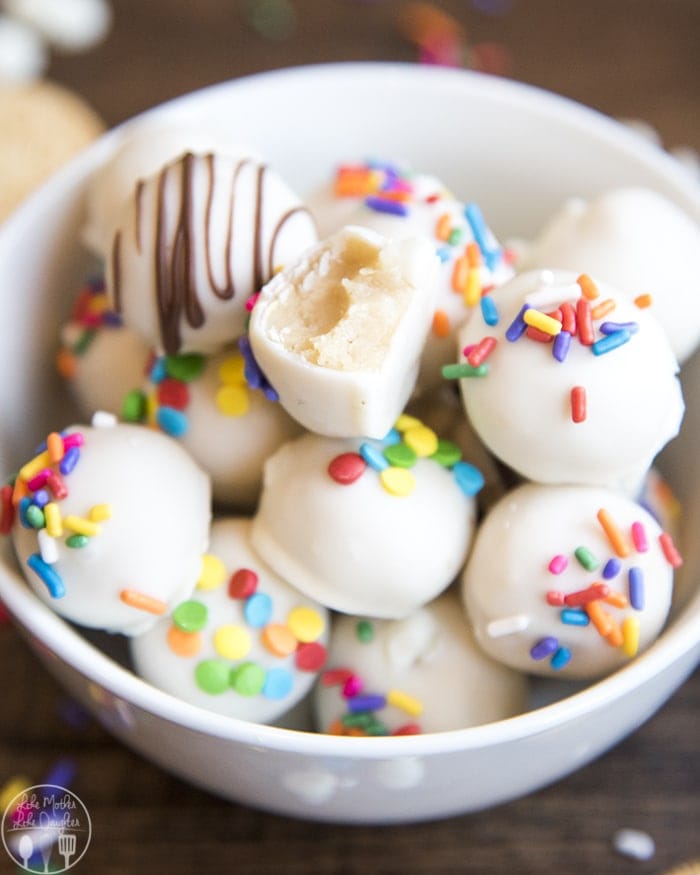 A bowl of golden Oreo truffles, topped with rainbow colored sprinkles.