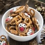A bowl of rolo pretzel reindeer treats decorated with candy eyes to look like reindeer.