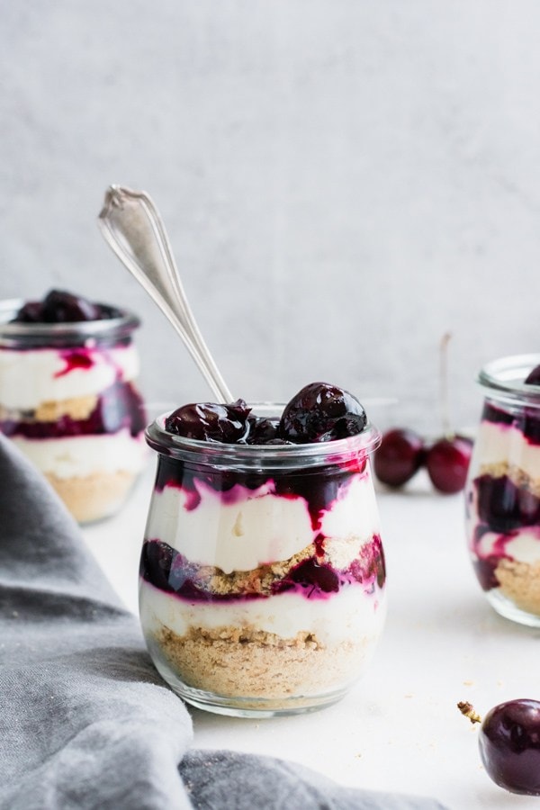 Blueberry cheesecake parfaits in small glass jars.