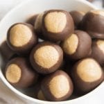 bowl of peanut butter balls dipped in chocolate up to the top third, that makes them look like buckeye nuts.