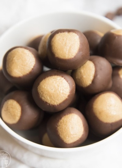 bowl of peanut butter balls dipped in chocolate up to the top third, that makes them look like buckeye nuts.