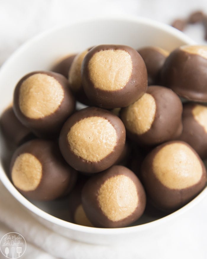 bowl of peanut butter balls dipped in chocolate up to the top third, that makes them look like buckeye nuts.