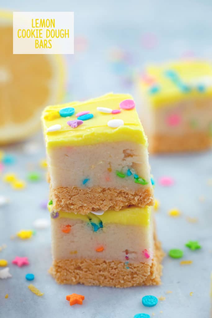 Lemon cookie dough bars stacked with yellow frosting and sprinkles.