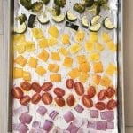 A baking pan with rainbow rows of colored roasted vegetables.