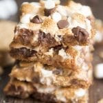 A stack of smores magic bars with toasted marshmallows and chocolate chips on top.