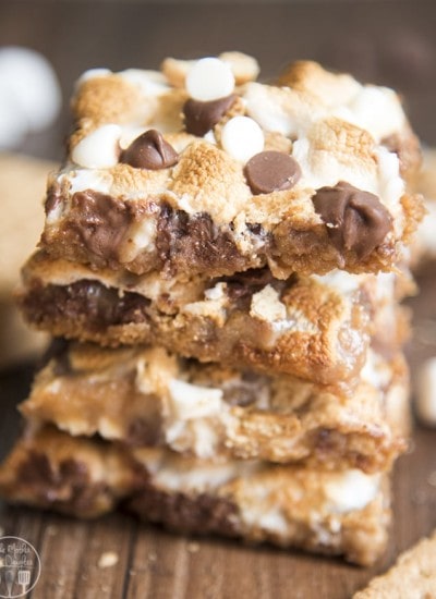 A stack of smores magic bars with toasted marshmallows and chocolate chips on top.