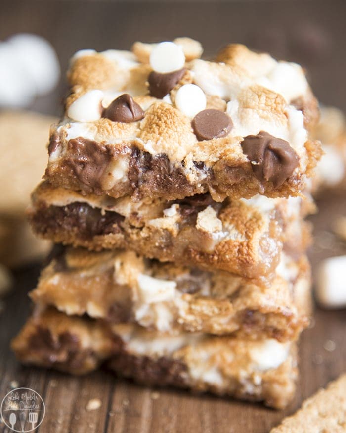 A stack of smores magic bars with toasted marshmallows and chocolate chips on top.