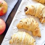 Apple pie crescent rolls decorated with icing over the top.
