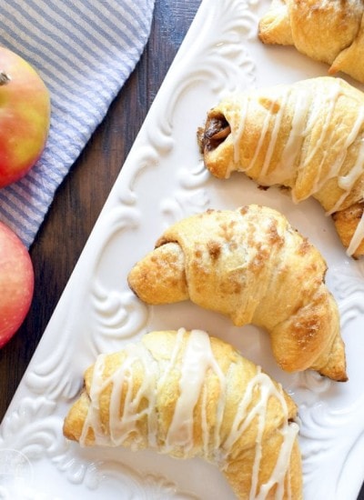 Apple pie crescent rolls decorated with icing over the top.