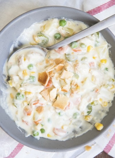 A gray bowl full of chicken pot pie soup with pie crust pieces in the middle.