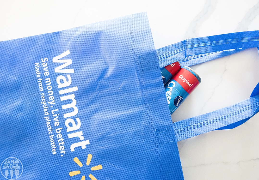 A reusable blue walmart bag with canned crescent rolls peaking out.