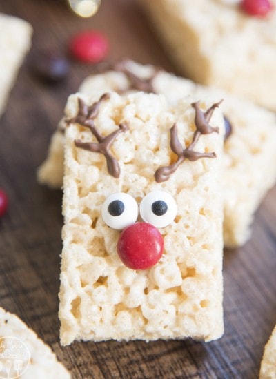 A rice krispie treat decorated with chocolate antlers, candy eyes, and a red m&m nose to look like a reindeer.