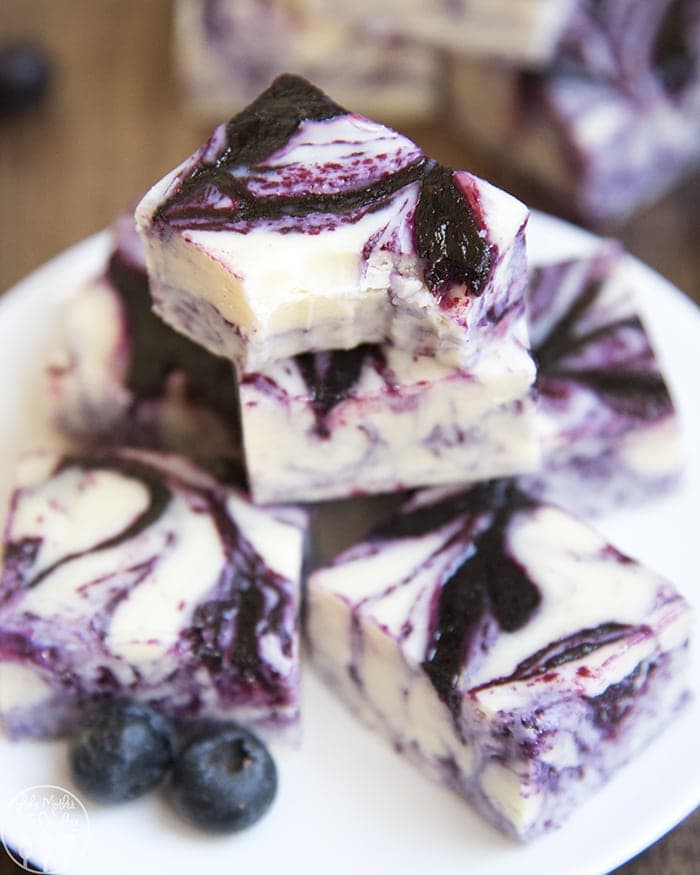 A pile of white chocolate fudge swirled with blueberry sauce. 