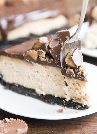 A slice of peanut butter cheesecake with a fork cutting into it.