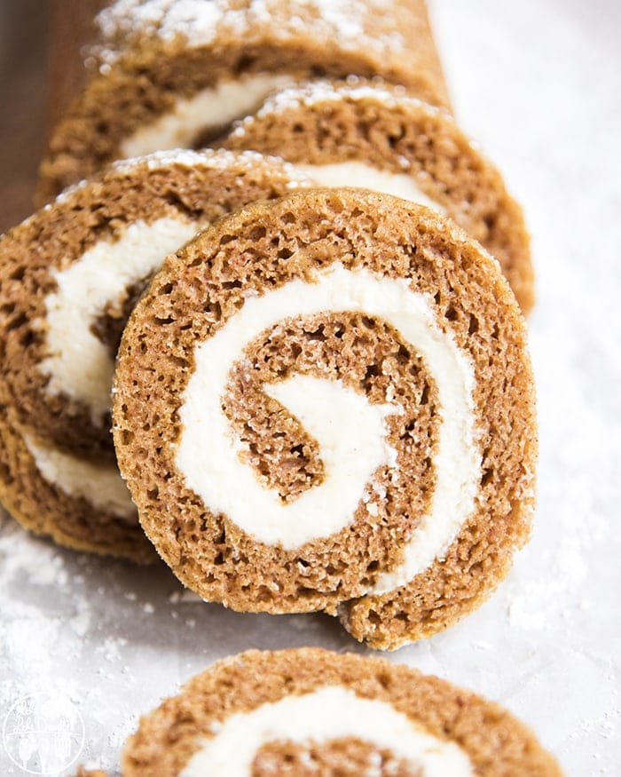 Pumpkin rolls swirled with cream cheese frosting stacked together.