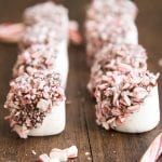 Two rows of marshmallows dipped in chocolate and crushed candy cane pieces.