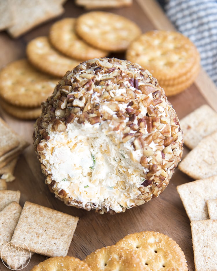 A cheese ball topped with chopped pecans. 