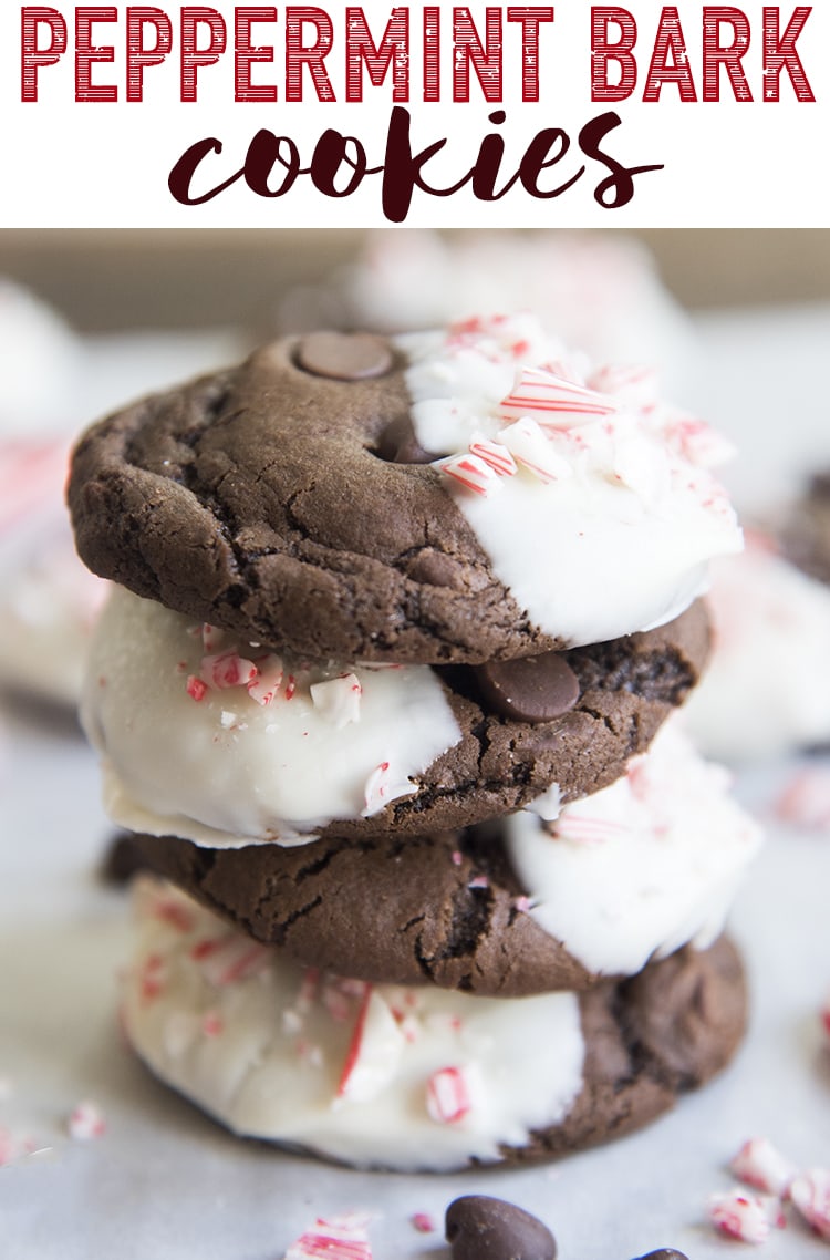A stack of chocolate cookies, each dipped in white chocolate with candy cane pieces on top.