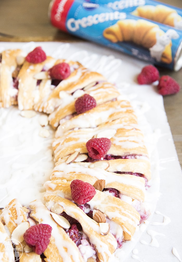A raspberry cream cheese danish ring on white parchment paper.