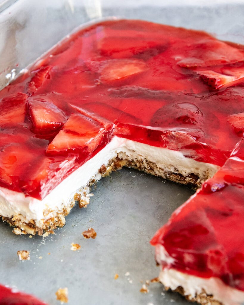 A pan of strawberry pretzel salad with a layer of pretzel crust, cheesecake filling, and jello on top.