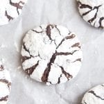 An overhead photo of chocolate crinkle cookies on a piece of parchment paper.