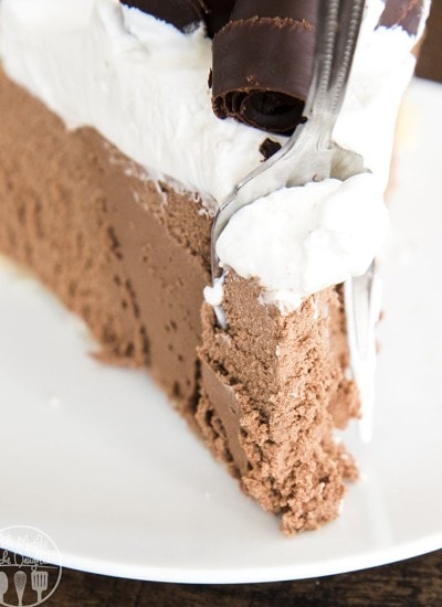 A close up of a slice of french silk pie with a fork taking a bite out of the front.