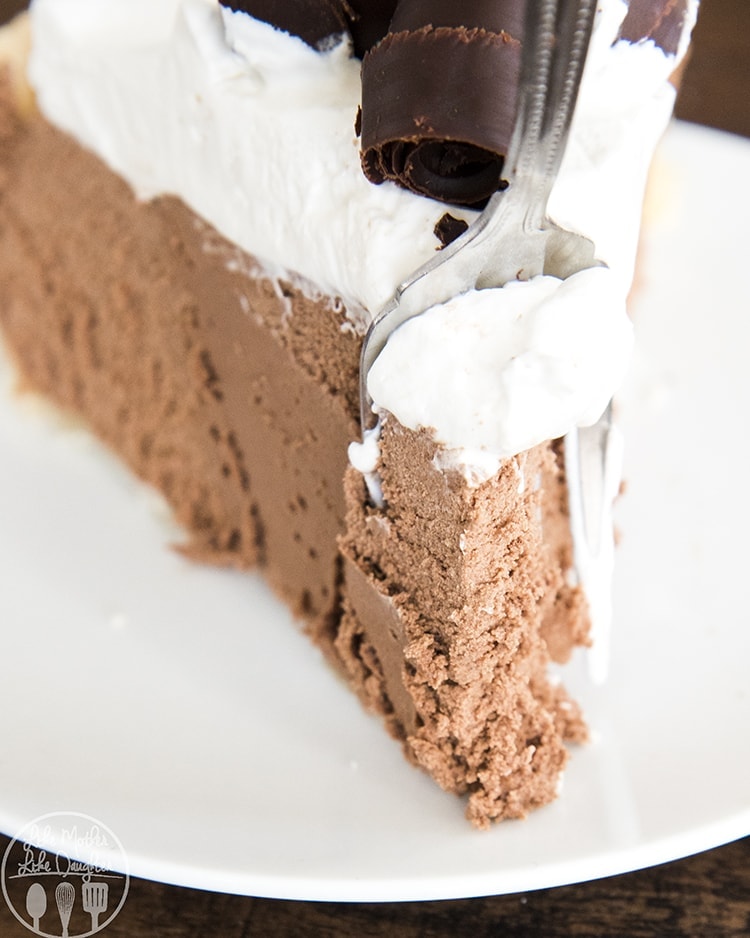 A close up of a slice of french silk pie with a fork taking a bite out of the front.