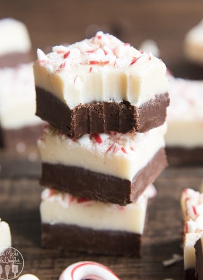 A stack of three pieces of peppermint bark fudge with a bite out of the top.