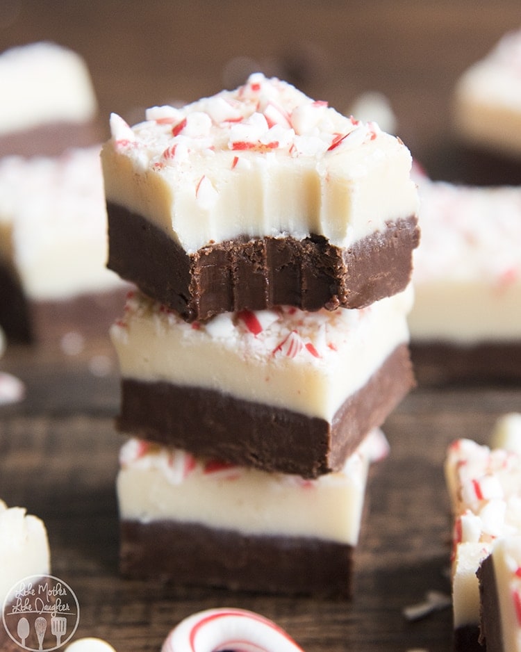 A stack of three pieces of peppermint bark fudge with a bite out of the top.