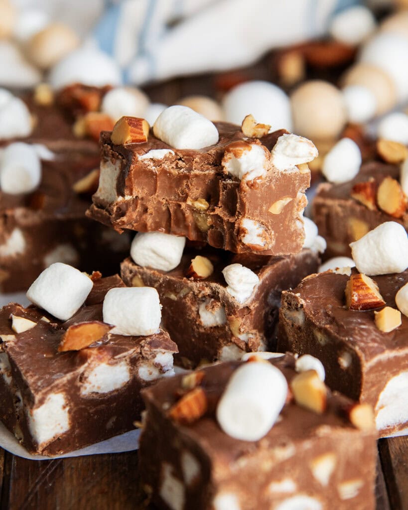 A pile of chocolate fudge with mini marshmallows, and one piece has a bite out of it.