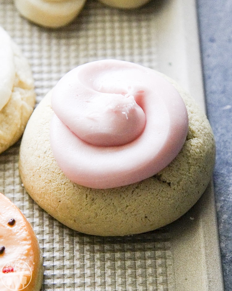 A thick sugar cookie topped with pink frosting.