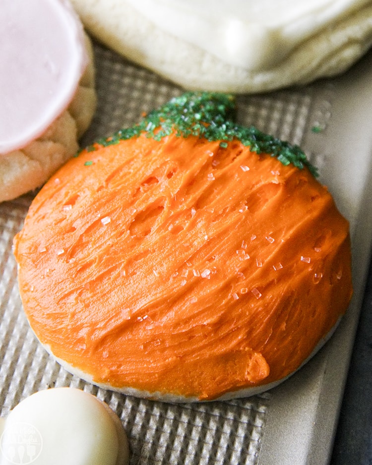 A sugar cookie decorated to look like a pumpkin.