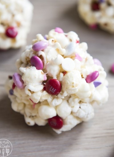 Close up image of valentine's day popcorn balls showing candy and white chocolate.