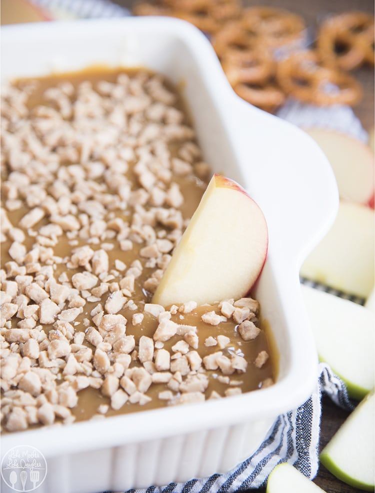 A baking dish full of caramel and cream cheese fruit dip. 